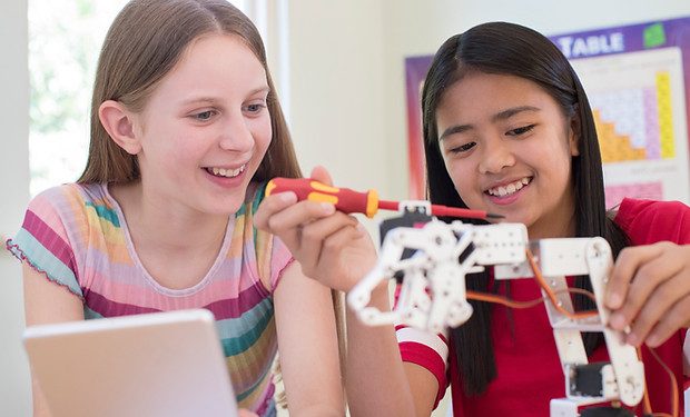 Two girls collaborating on a robotics build