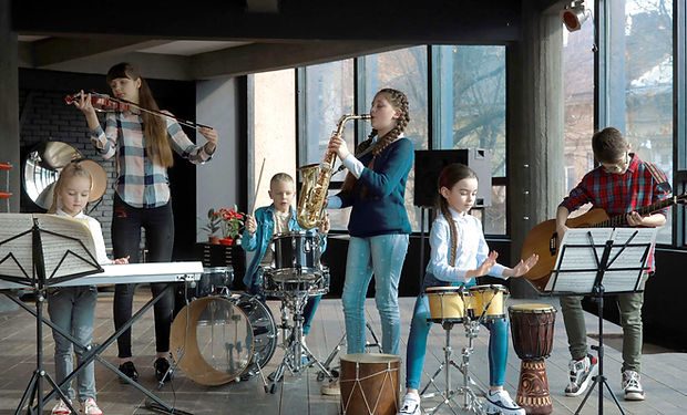 River Tech students in a music class — violin, drums, saxophone, and guitar